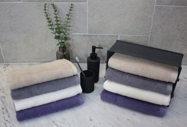 Basic towels in beige, gray, ivory and purple on a bathroom counter